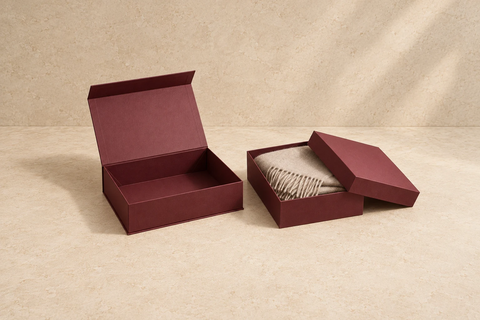 Burgundy collapsible magnetic gift box beside a fixed lid-and-base gift box holding a scarf