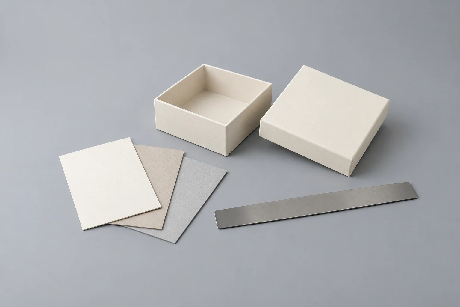 Ivory gift box and lid with individual paperboard sample cards laid out for material review