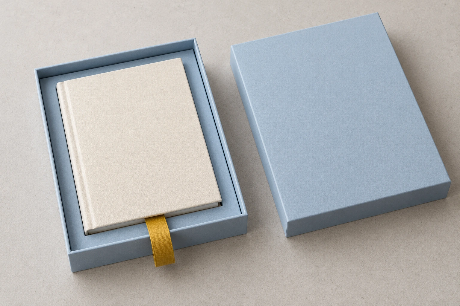 Pale blue gift-box concept showing a ribbon routed beneath a notebook with an accessible free end