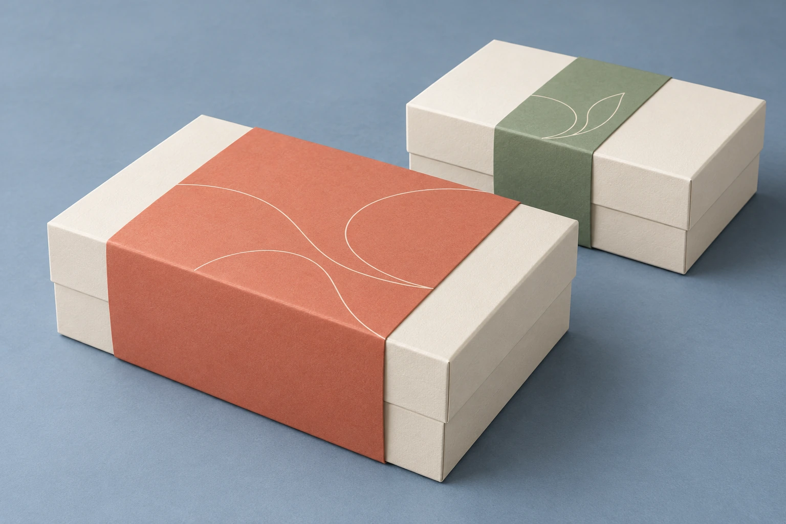 Ivory rigid gift boxes with a coral paper sleeve and a narrower sage belly band